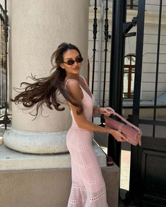 Close-up of pink crochet knit dress featuring intricate hollow wave patterns and V-neck line