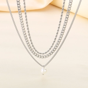 Close-up of triple-layered silver necklace with rope, Cuban, and box chains and a pearl