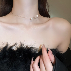 Close-up of elegant gold pearl choker necklace showing delicate metal and pearl details