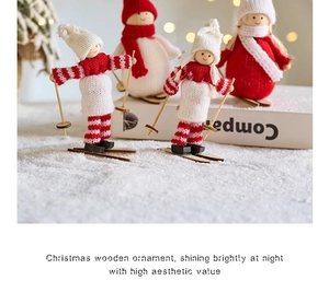 Detail view of handcrafted wooden Santa figurines with knitted hats in a warm snow scene