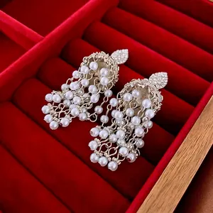Elegant vintage heart stud earrings with white pearl tassels on a red velvet box