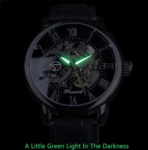 Luminous watch hands and Roman numerals glowing green on skeleton dial in the darkness