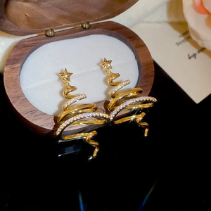 Macro detail of gold plated Christmas tree earrings with spiral design and sparkling cubic zirconia