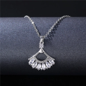 Sparkling silver fan-shaped necklace with zircon stones on a dark pedestal stand