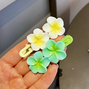 Detail of sweet plumeria flower duckbill clips with matte finish for girls hair