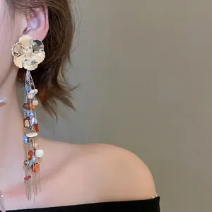 Bohemian silver floral tassel earrings with colorful resin beads worn by a model
