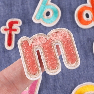 DIY colorful alphabet letter patches for clothing decoration on blue denim fabric
