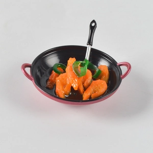 Close-up of miniature red pan with realistic shrimp and spatula for dollhouse play