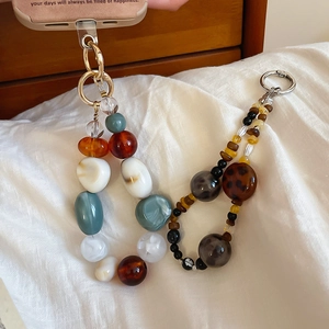 Detail view of vintage acrylic beaded phone straps with tortoiseshell resin and gold clasps