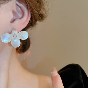 Close-up of elegant flower stud earrings with white mother-of-pearl petals and pearl center