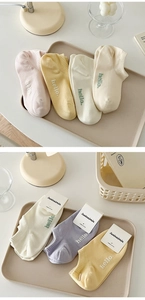 Detail view of colorful combed cotton low-cut socks with cream colors and hello letter embroidery