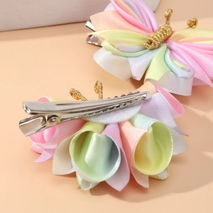 Detail of handmade butterfly hair clip featuring colorful gradient fabric and metal crocodile grip