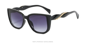 Detail of oversized sunglasses with purple gradient lenses and gold mesh temple accents