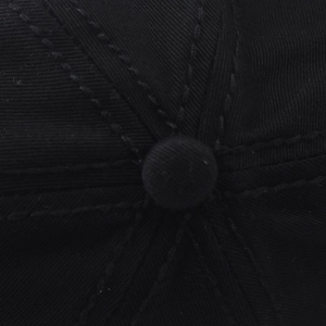 Nahaufnahme des Knopfes und der Twill-Stoffnähte auf der schwarzen Baseballkappe