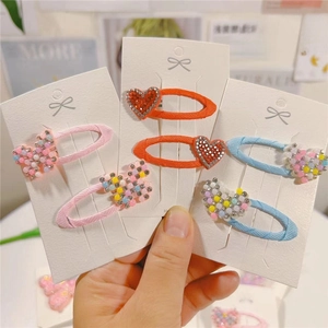 Close-up of cute cartoon hair clips with colorful rhinestones on display cards