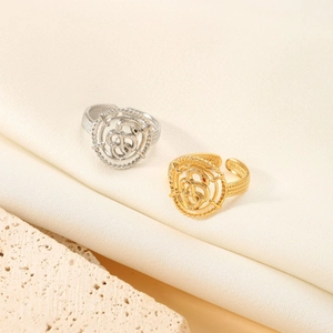 Detailed top view of gold and silver snake rings on silk fabric with stone accent