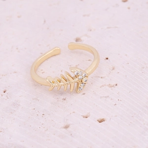 Macro shot of gold fishbone ring with pavé zircon detail on stone background