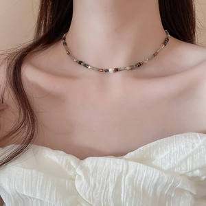 Close-up of beaded choker necklace with natural agate, ceramic beads and a pearl accent