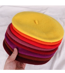 Detailed close-up showing multiple colorful wool beret hats in various vibrant shades
