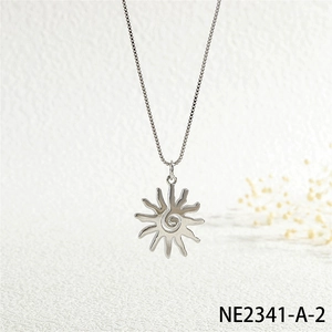 Detailed view of silver sunburst pendant with spiral center and cubic zirconia on box chain