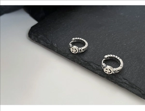 Detail view of vintage S925 silver smiley face earrings with twisted chain texture
