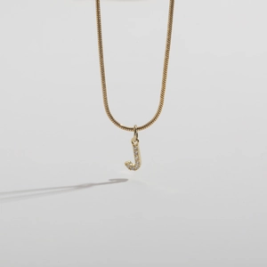 Detailed view of 14k gold plated snake chain necklace with a sparkling letter J pendant