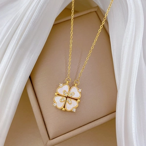 Détail du collier trèfle doré avec incrustation de nacre et diamants dans un écrin à bijoux