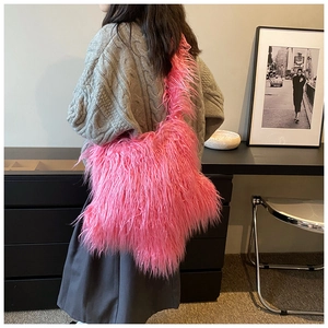 Close-up of bright pink plush faux fur shoulder bag worn by model in a minimalist home setting