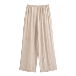 Detail of beige wide-leg trousers with textured crinkle fabric and elastic waistband