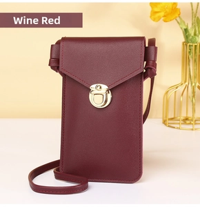 Detail of wine red lychee leather phone bag featuring a gold metal buckle and shoulder strap