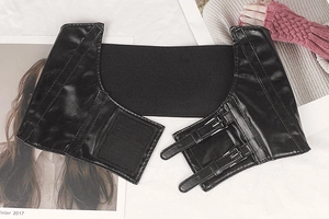 Detail of wide black corset belt showing faux leather texture and double metal buckles