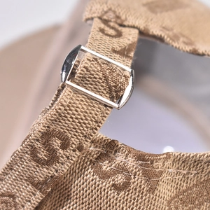 Macro detail of plaid fabric baseball cap featuring metal buckle and monogram embroidery