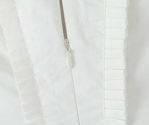 Detailaufnahme des verdeckten Reißverschlusses und der Falten an einem weißen Kleid