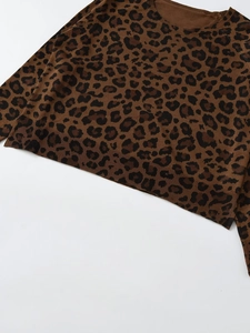 Detailed view of leopard print knit sweater texture and ribbed neckline finishing