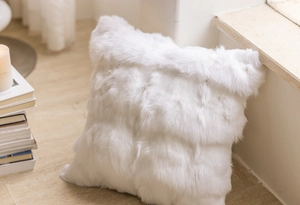 Macro detail of soft white faux fur pillow case with fluffy texture in cozy luxury home setting