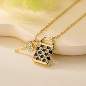 Macro detail of 18K gold plated checkerboard lock and key pendant necklace with crystals