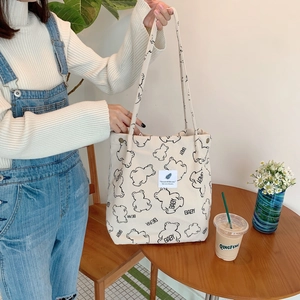 Detail of corduroy shoulder bag showing cute cartoon bear print and soft fabric texture