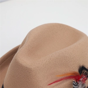 Dettaglio del cappello di lana cammello con una piuma colorata vintage sul nastro