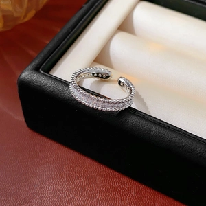 Détail du lot de bagues ouvertes en argent avec micro-pavé de zircons sur boîte en cuir