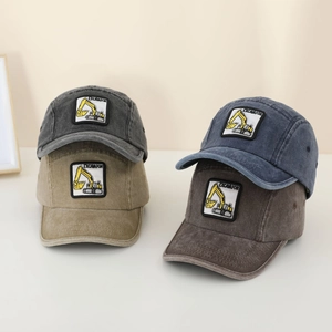 Detailed close-up of excavator embroidery and washed vintage fabric texture on caps