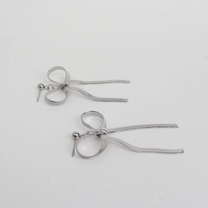 Detailed view of silver stainless steel bow earrings with hanging snake chain tassels