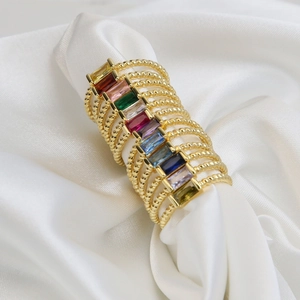 Macro detail of multi-layered 18k gold brass ring with colorful baguette birthstones