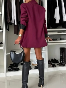 Elegant wine red longline blazer with contrasting black cuffs shown in a minimalist setting