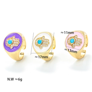 Detailopname van vergulde Hamsa Hand ringen met kleurrijk emaille en ingelegde edelstenen