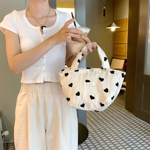 White textured canvas tote bag with black heart patterns and aesthetic label