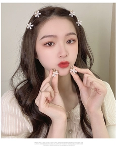 Detailed view of pearl flower hair clips and matching earrings set on a model