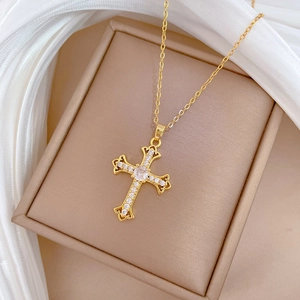 Close-up of golden titanium steel cross necklace with cubic zirconia on jewelry box