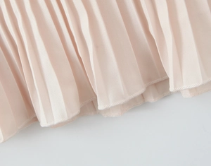 Detail of light pink pleated chiffon fabric with fine hem stitching and drape texture