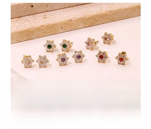 Detailed close-up of tiny daisy stud earrings with colorful crystals and zircon inlays