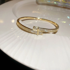 Detail of 18k gold plated snake-shaped open bracelet featuring pavé zircon crossover design